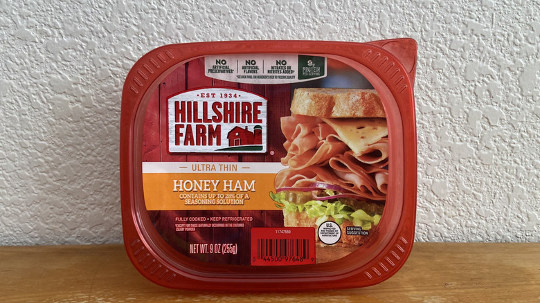 Package of Hillshire Farm honey ham propped up on a wooden table