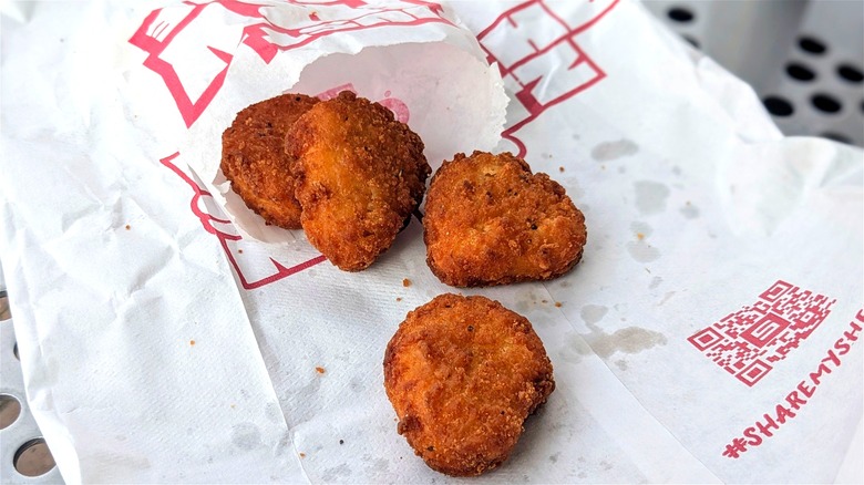 Chicken nuggets spilling out of a bag on white Sheetz-branded paper