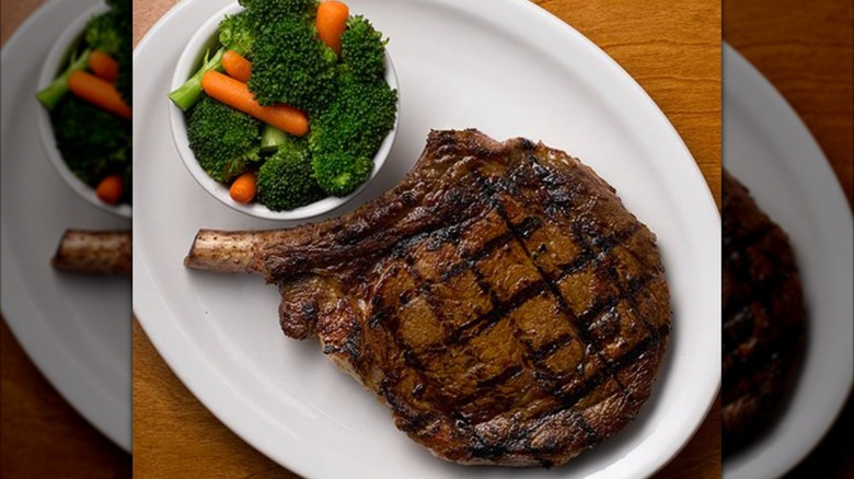Texas Roadhouse Bone-in Ribeye with side of broccoli and carrots