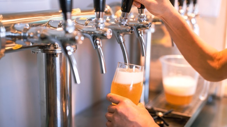 Craft beer being poured from a tap.