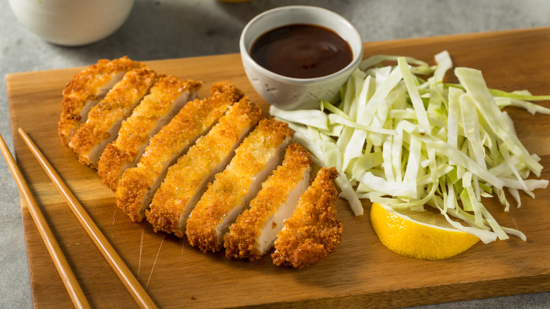 chicken katsu with shredded cabbage and a lemon wedge