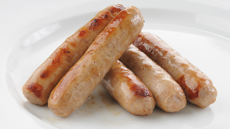 Links of breakfast sausage on white plate