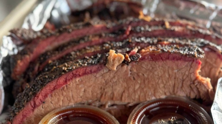 Bless Your Heart BBQ brisket, sliced with sides of sauces