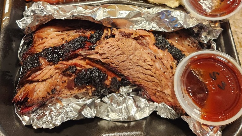 Beef Brisket with side of sauce from Goody Coles Smokehouse & Catering Co.