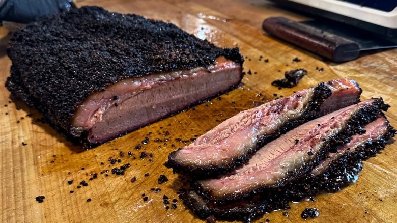 Slice Brisket on wooden cutting board from Red White & Que Smokehouse