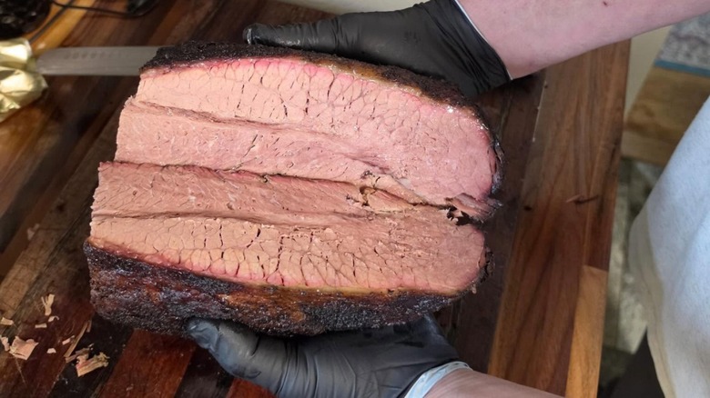 Gloved hands holding a brisket ready for slicing at Jeff's Texas Style BBQ