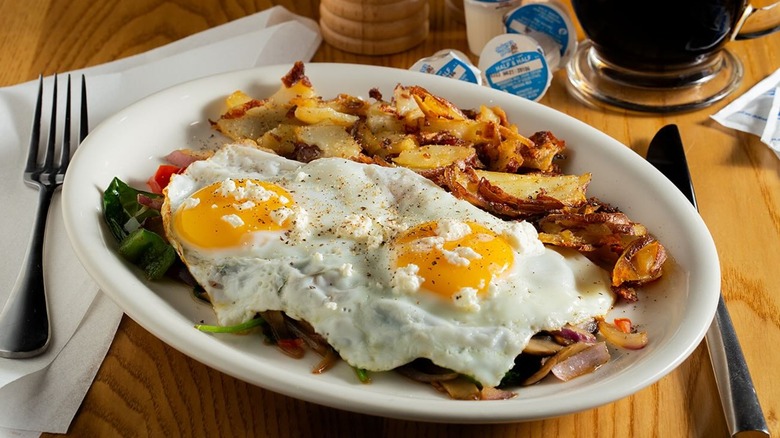 Eggcellent restaurant breakfast plate with two fried eggs and breakfast potatoes