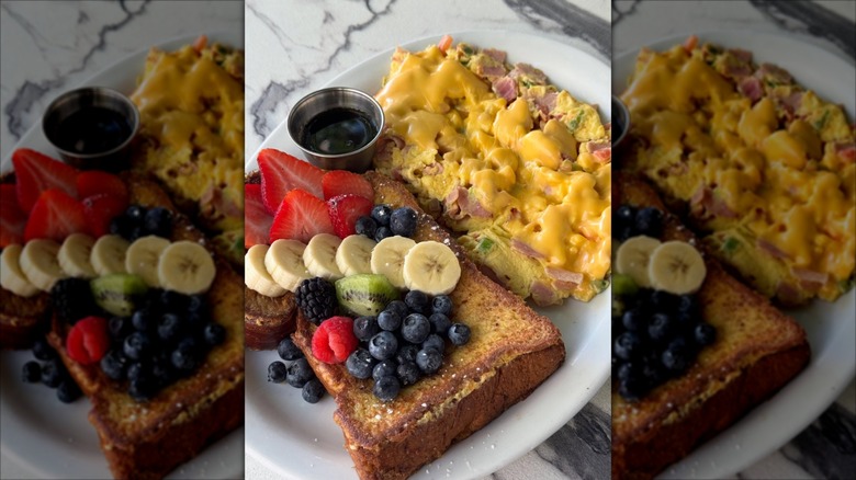 Bistro Cafe French toast topped with sliced fruit and a side of Monte Carlos scrambled eggs with American Cheese and ham