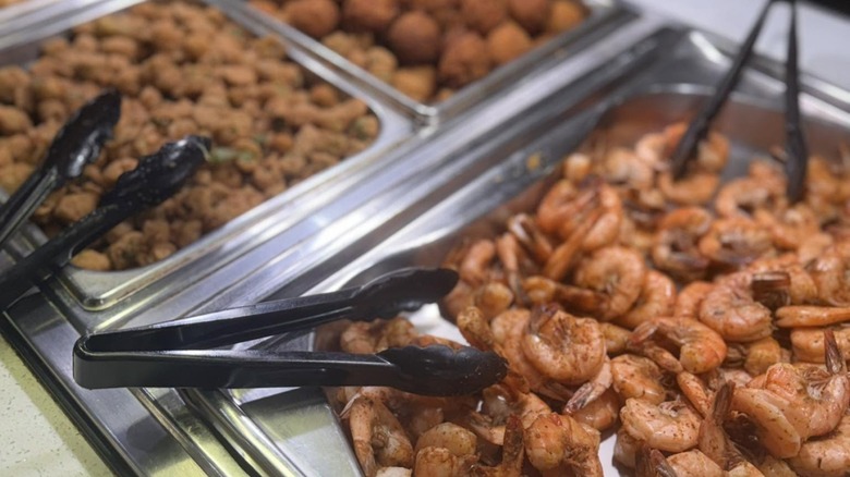 Silver trays of Fried okra, shrimp, and hush puppies on buffet at Wood Grill Buffet
