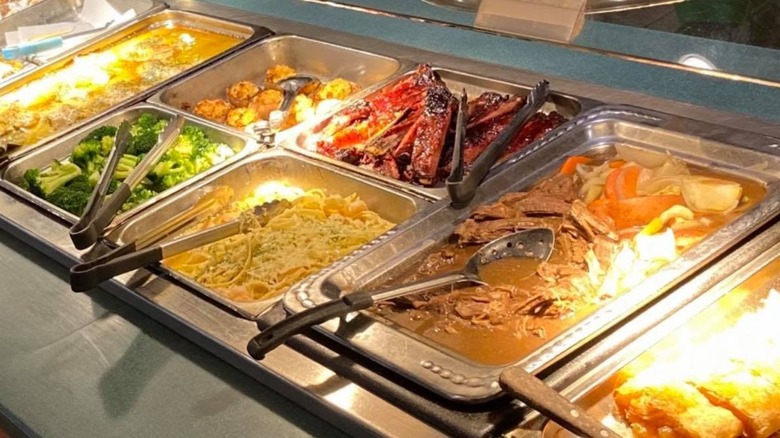 Buffet setup with foods like roast, pasta, and broccoli at Pacific Buffet and Grill