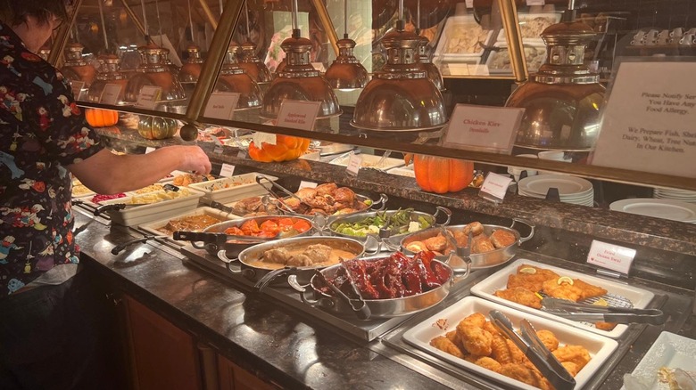 woman making a plate of items at the Red Apple Buffet
