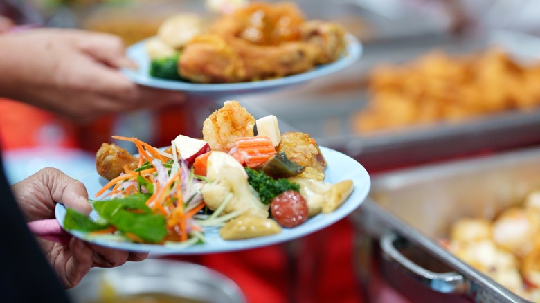 A plate filled with assorted Chinese buffet dishes, including vegetables, fried seafood, and mixed appetizers