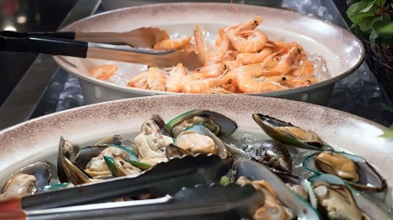 Oysters and shrimp in trays with serving tongs at Fuji Japanese Buffet