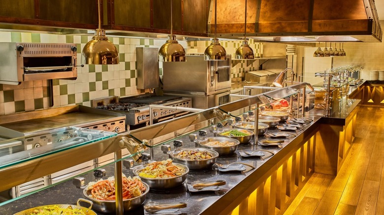 Buffet line at Lucky H Buffet with grills and ovens in an open kitchen in background