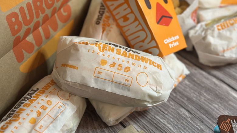 Burger King chicken sandwiches and items laid out on table.