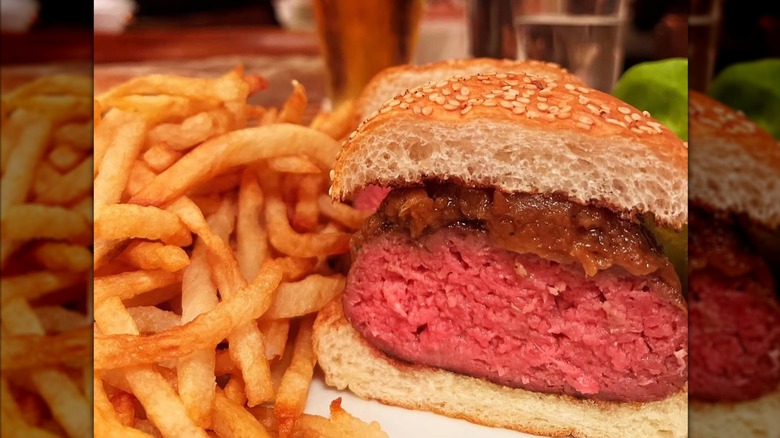 Fries and a Minetta Burger cut in half at Minetta Tavern in NYC.