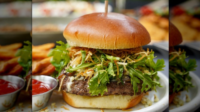 Avon Burger on a plate with fries and a small bowl of ketchup