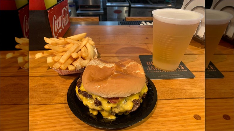 Double cheeseburger and fries plated on wooden table