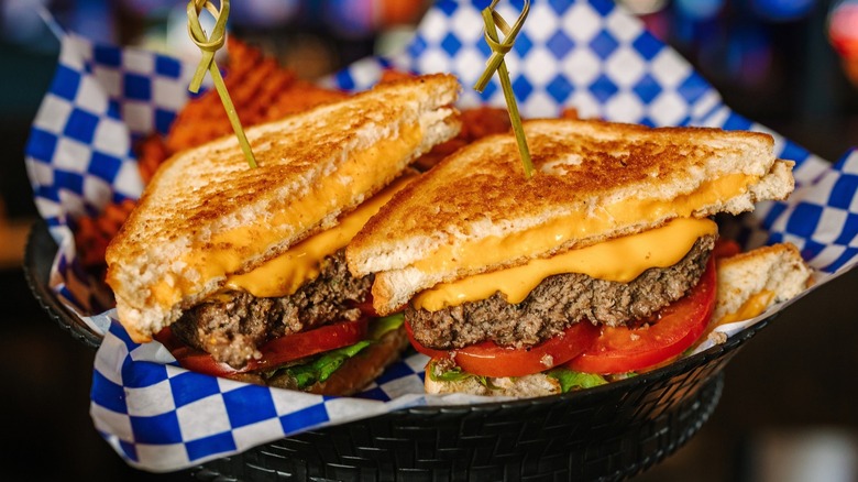 Grilled Cheese Cheeseburger on blue and white checked paper in a basket