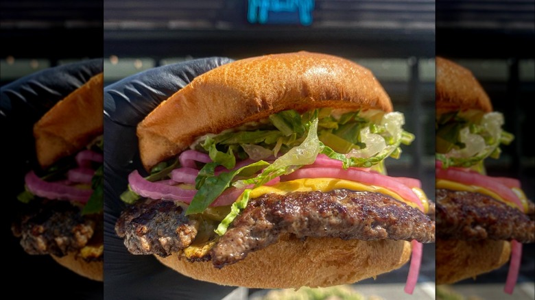 Black-gloved hand holding a House Burger