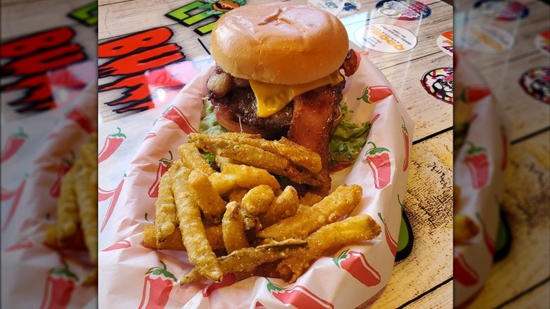Tremor Bacon Cheeseburger in a paper-lined basket with a side of fries