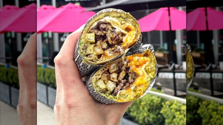 A person holds a breakfast burrito from Coffee Commissary outside the Fairfax location