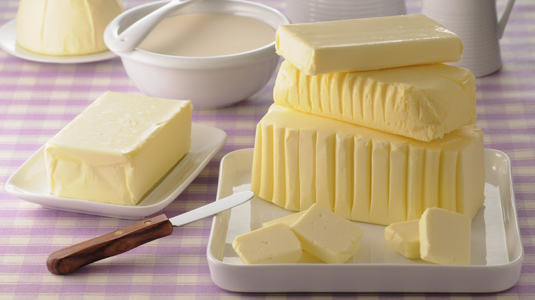 Several blocks of butter on purple gingham cloth
