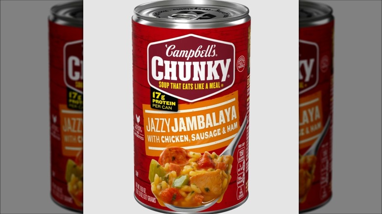 A can of Campbell's Jazzy Jambalaya soup on a grey background.