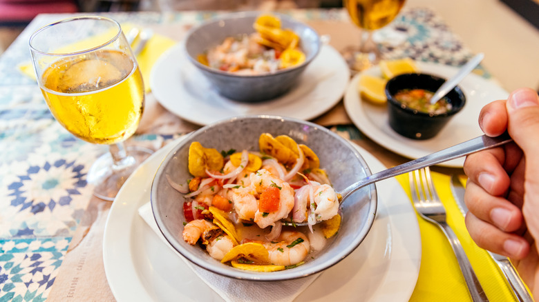 Shrimp ceviche, served with red onion, lime, herb sauce, and tomatoes