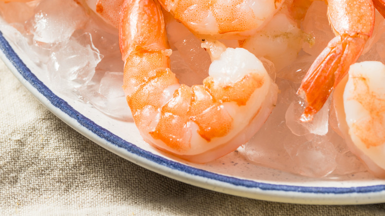 Cooked shrimp with sauce and a sprig of parsley
