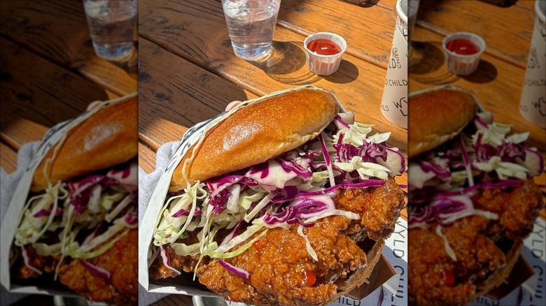Wyld Style chicken sandwich from Wyld Child held over wooden table