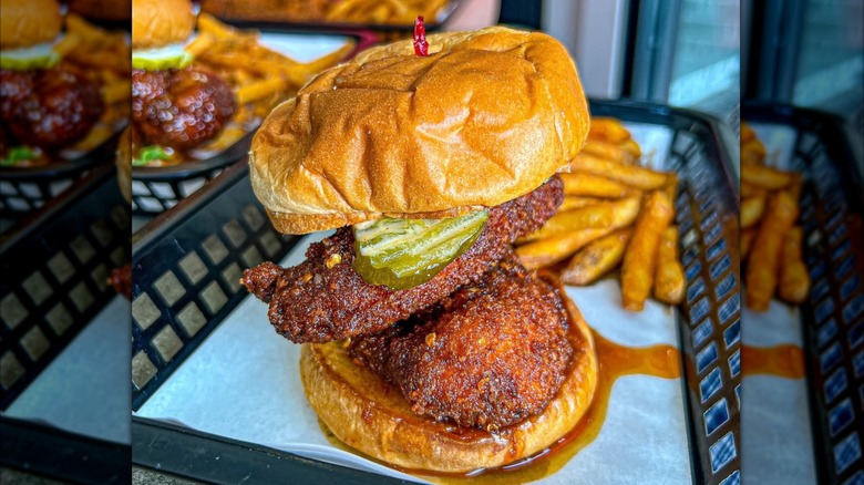 Sauced by Alfaro Nashville Hot Chicken Sandwich in a basket with fries