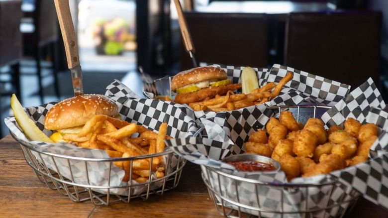 Saint Bibiana Fried Chicken Sandwiches in baskets with fries, on a restaurant table