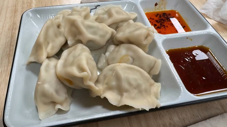 Steamed dumplings from Happy Dumpling, on tray with sauces.