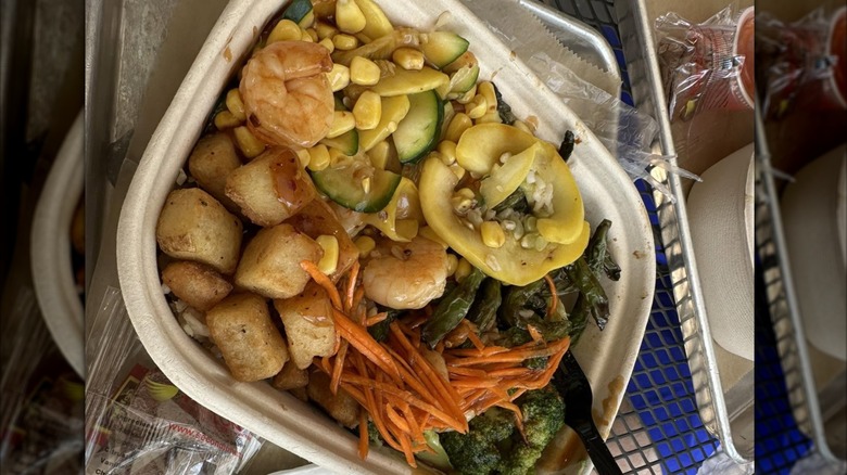 Build Your Own Bowl with shrimp, broccoli, carrots, corn and squash from EvoWok, in takeout container.