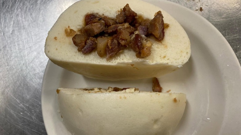 Meat bun from Tai Tung Restaurant on white plate.