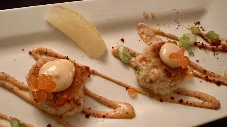 Two crab cakes at 315 Cuisine, drizzled with sauce