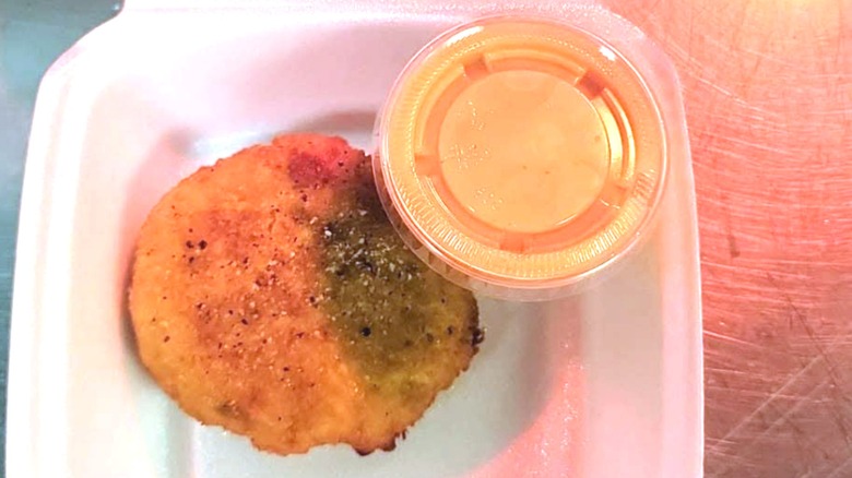 Single Crab cake with side container of sauce at Blalock's Seafood Restaurant