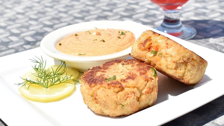 Two Crab cakes with sliced lemon and side dish of Ancho Lime Aioli at DiMillo's On the Water