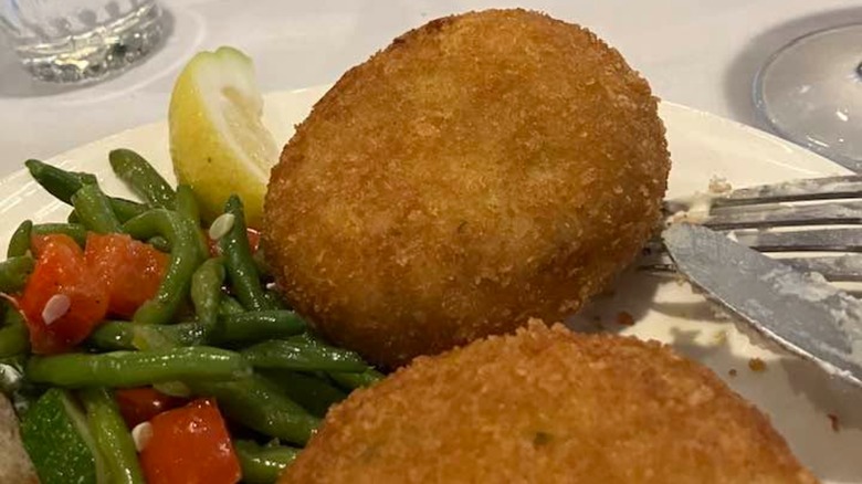 Crab Cakes with side of green beans and lemon slice at Crab Trap