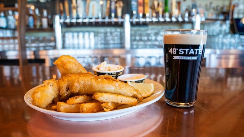 Beer glass next to fish and chips plate