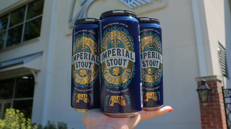 Three beer cans on hand palm