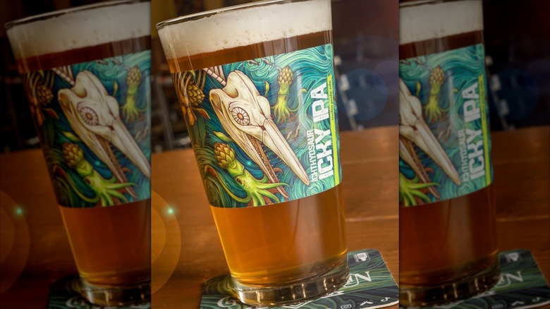 Filled tall beer glass with ichthyosaur label on side