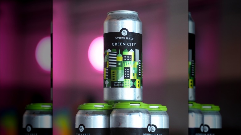 Aluminum can of Green City beer on top of a four pack of the beer