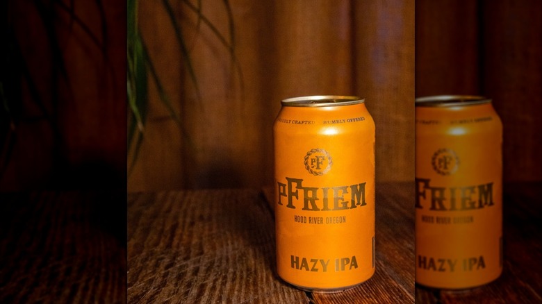 One orange can of Hazy IPA beer on wooden table