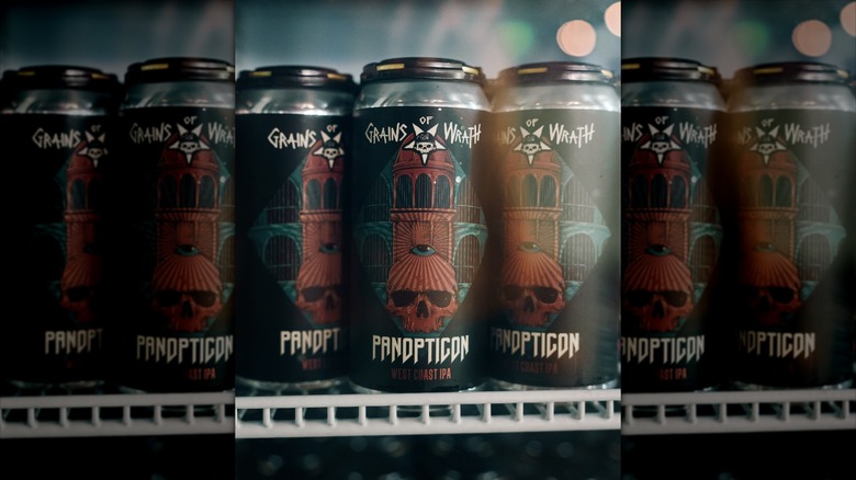Three tall black beer cans on fridge shelf