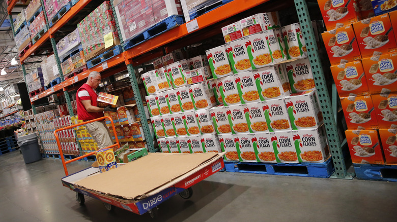 A Costco employee restocks the shelves with cereal.