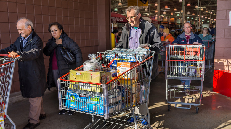 A line of people flooding out of a busy Costco.