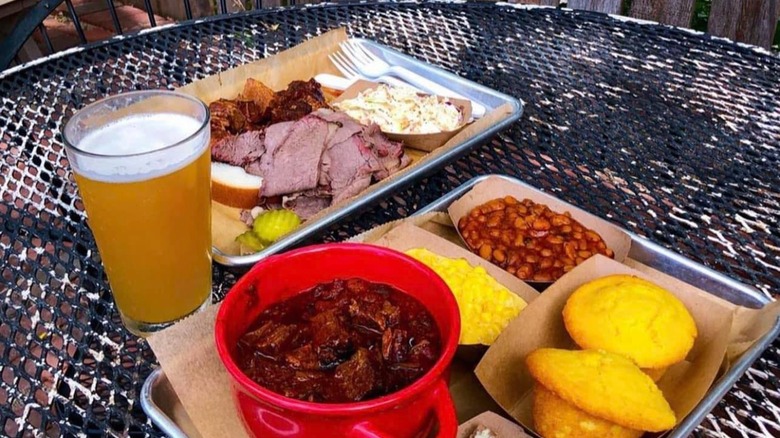 BBQ spread from Woodyard Bar-B-Que with glass of beer, cornbread muffins, beans, slaw and meats