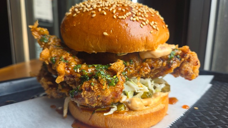 Lime cilantro glazed double fried PCF chicken thigh, buttermilk slaw, chipotle mayo and spicy pickle on a seeded brioche bun special sandwich from Block 16